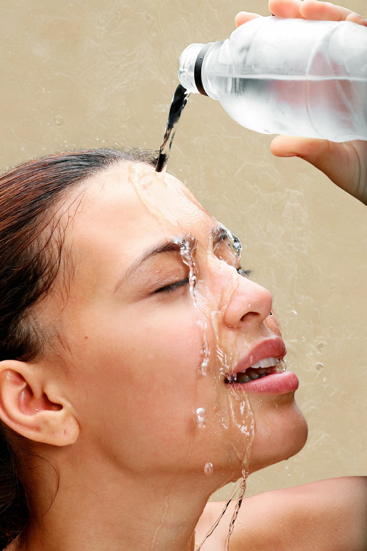 A female model pouring water over her face